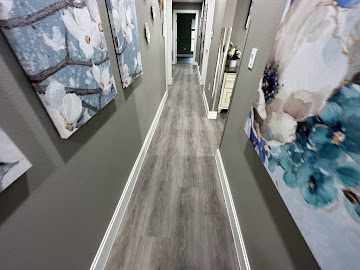 Hallway with new grey wood-look flooring and crisp white baseboards