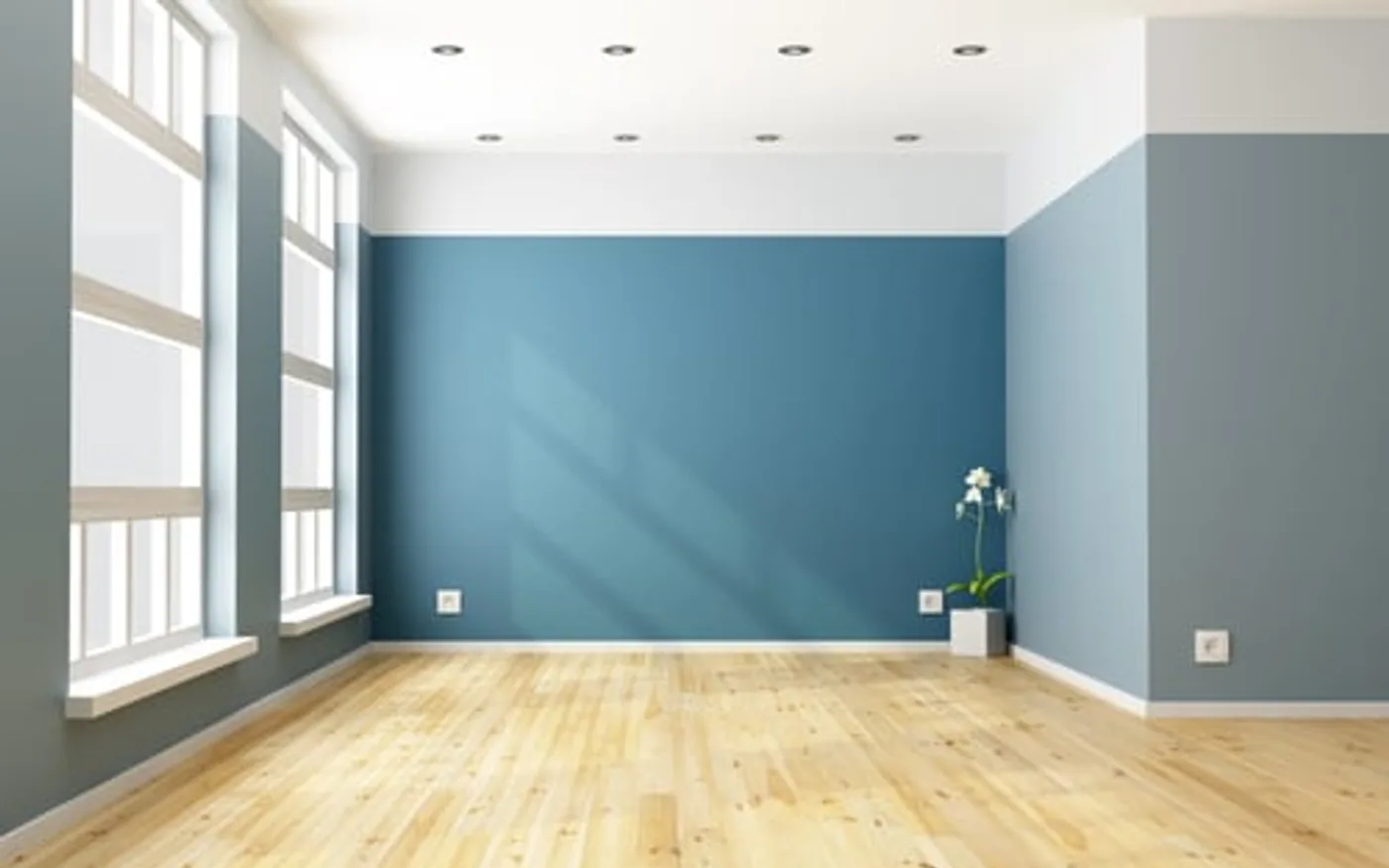 Freshly painted blue interior wall with light wood flooring and clean trim lines