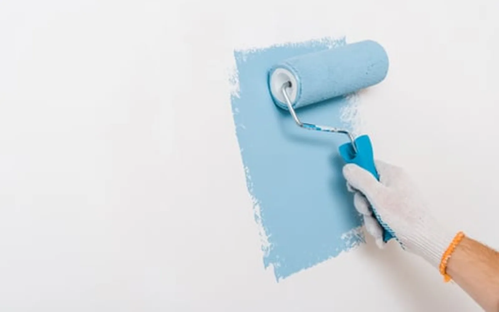 Painter rolling a fresh blue coat onto a smooth interior wall in a Garland, TX home